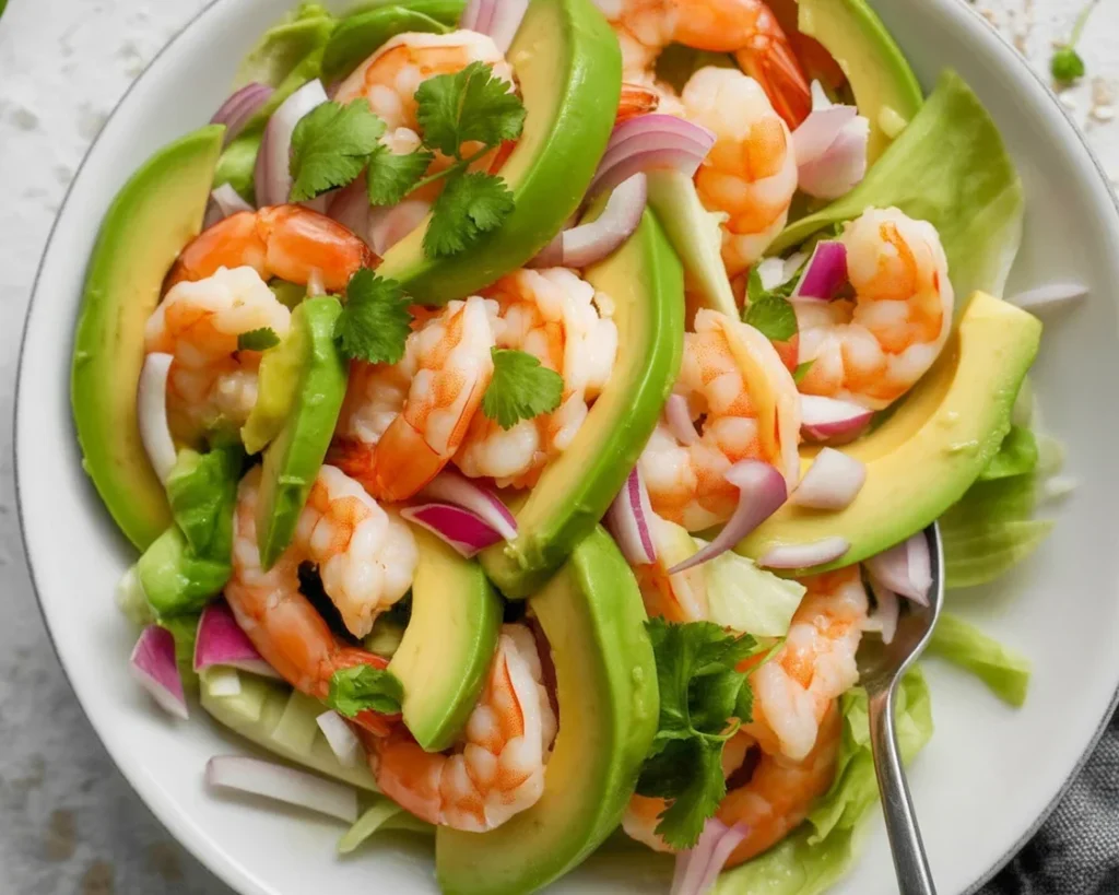 Shrimp avocado salad with lime dressing, fresh ingredients, and vibrant colors.