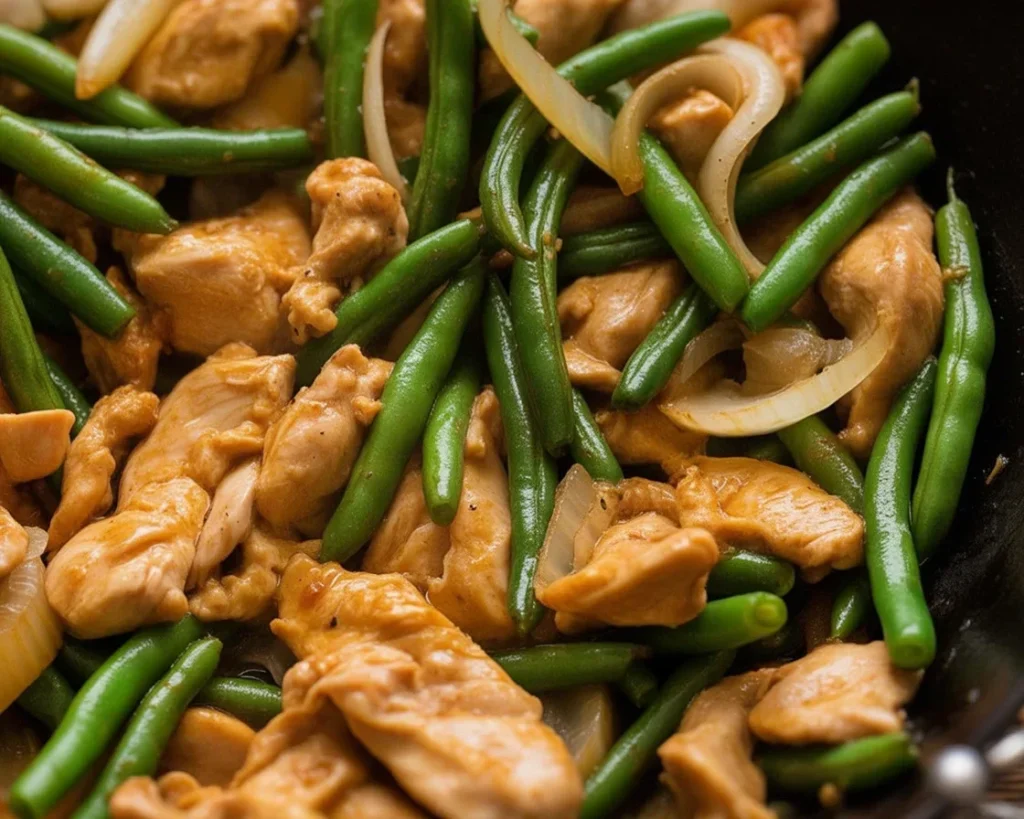 Delicious chicken and green bean stir fry with homemade sauce served on a plate.